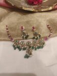 Trendsetting Red AD Stone Floral Necklace with Green Beads